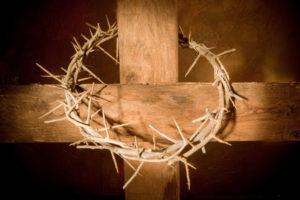 Crown of thorns hanging on a wooden cross at Easter